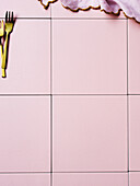 Cake forks and napkin on a pink tile background