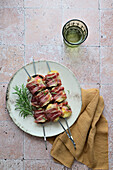 Mushrooms with cheese filling and bacon coating on skewers