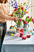 Woman decorates bouquet of flowers on Easter table