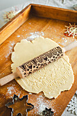Butter biscuit dough with Christmas motif and snowflake-shaped cutter