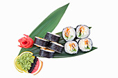 Free-standing plate of sushi rolls with eel and cucumber, served on a bamboo leaf