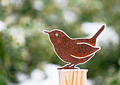 Garden decoration made of a small rusty bird covered with hoarfrost