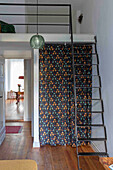 View of room with gallery, ladder and patterned curtain