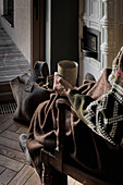 Elderly person on wooden chair with ceramic cup in hand