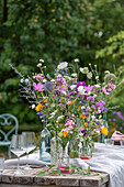 Gedeckter Tisch mit Blumenschmuck, Ringelblume (Calendula), Kosmee (Cosmos), Flammenblume (Phlox), Skabiose, Kugellauch (Allium) in Vasen