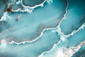 Aerial view of geothermal pools with woman relaxing in Terme di Saturnia,Tuscany,Italy
