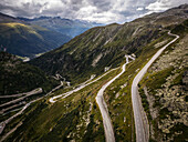 Aerial view of winding road through majestic alpine mountains and serene valley,Oberwald,Switzerland