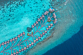 Luftaufnahme der Bungalows eines Luxusresorts entlang des Riffs auf der Insel Fesdhoo auf den Malediven