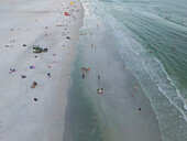 Aerial view of colorful lifeguard houses on a beautiful sandy beach with people enjoying the sunny shoreline,Siesta Key,Florida,United States