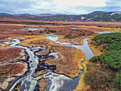 Luftaufnahme der malerischen Caldera Uzon mit lebhaftem Fluss und schroffen Bergen im Kronotsky-Nationalpark, Kamtschatka-Halbinsel, Russland