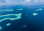 Luftaufnahme eines wunderschönen Atolls mit Barriereriff, umgeben vom Indischen Ozean, Malediven
