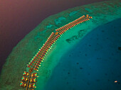 Aerial view of bungalows along the reef at sunset on Baa Atoll,Kanifushi Island,Maldives