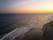Luftaufnahme eines ruhigen Strandes bei Sonnenuntergang mit einer Person, Pine Knoll Shores, Vereinigte Staaten