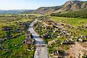 Luftaufnahme von antiken Ruinen und malerischen Wegen, umgeben von Bergen und Grün, Pamukkale, Türkei