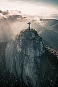 Aerial View Of Afternoon Light Rays Shining Upon Christ The Redeemer Statue On Corcovado Mountain In Rio De Janeiro,Brazil