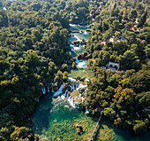Aerial view of a picturesque waterfall cascading through lush greenery and a tranquil river,Skradin,Croatia
