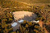 Aerial view of the ancient theater and amphitheater surrounded by trees in a beautiful landscape,Asklipiio,Greece