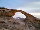 Aerial view of breathtaking rock formation arch in the desert under a dramatic sunset,Aqaba,Jordan