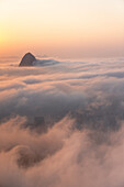 Luftaufnahme des Sugarloaf Mountain Peak bei Sonnenaufgang in Rio de Janeiro, Brasilien, über einer Decke aus niedrigen Wolken