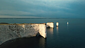 Aerial view of the Old Harry Rocks landmark with white cliffs lit by the late afternoon Sun light in Studland,Dorset,United Kingdom