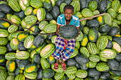 Dhaka,Bangladesh - 11 April 2019: Aerial view of a person holding a green watermelon on a commercial boat at Old Dhaka river port along Buriganga river in Dhaka,Bangladesh