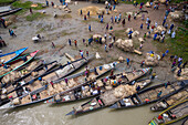 Dhaka,Bangladesh - 04 August 2021: Aerial view of people trading and sailing using long fishing canoes along Kaliganga river,Ghior,Dhaka province,Bangladesh