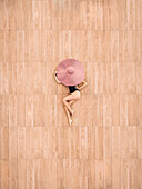 Aerial view of a girl lying on a wooden floor,Sicily,italy