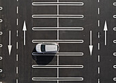 Aerial view of a white car in an almost empty parking lot in Ambivere,Lombardy,Italy