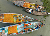 Aerial view of people trading with fruits and vegetables on boats along the river in Dhaka,Bangladesh