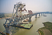 Aerial view of a building site while assembling the Padma bridge,the longest rail and highway bridge in Bangladesh crossing the Padma river,Zajira,Dhaka,Bangladesh