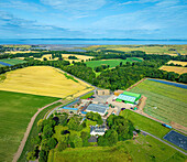 Luftaufnahme von schönem Ackerland mit grünen Feldern und Bäumen unter einem ruhigen Himmel,Longniddry,Vereinigtes Königreich