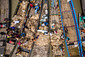 Dhaka,Bangladesh - 04 August 2021: Aerial view of people trading and sailing using long fishing canoes along Kaliganga river,Ghior,Dhaka province,Bangladesh