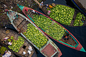 Aerial view of several small commercial boats with people unloading watermelons at Old Dhaka river port along Buriganga river in Dhaka,Bangladesh