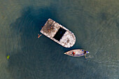 Keraniganj,Bangladesh - 20 June 2020: Aerial view of a few kids playing and swimming in Buriganga river,jumping from a wreck old boat,Dhaka,Bangladesh