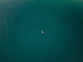 Aerial view of a two tiny people canoeing into the sea in Cefalù,Sicily,Italy
