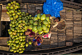 Dhaka, Bangladesch - 11. April 2019: Luftaufnahme von ein paar Menschen, die auf einem Holzboot stehen und in die Kamera lächeln, während sie frische Mangofrüchte von einem Boot in Dhaka, Bangladesch, abladen