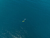 Aerial view of a two tiny people canoeing into the sea in Milazzo,Sicily,Italy