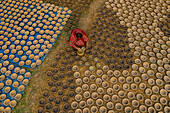 Sahajanpur,Bangladesh - 27 January 2020: Aerial view of a woman patiently hardworking clay pots in Rajshahi state,Bangladesh