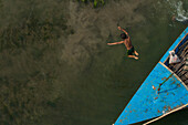 Dhaka,Bangladesh - 23 January 2017: Aerial view of kids playing in the water jumping from a fishing boat,Bangladesh