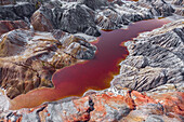 Luftaufnahme der Marslandschaft der industriellen Produktion von feuerfestem Ton mit einem rot gefärbten Wasserreservoir, Bogdanowitsch, Swerdlowskaja oblast, Russland