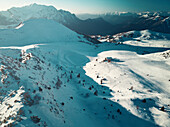 Aerial view of a ski resort and its slopes while a soft afternoon light the mountain range in Piani di Bobbio,Lombardy,Italy