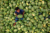 Dhaka,Bangladesh - 27 March 2022: Aerial view of people among the watermelons at work on the Buriganga River