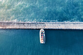 Aerial view of a fishing boat docked in a harbour,with blue water,creating a minimalist image,Cape Town,Western Cape,South Africa