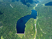 Luftaufnahme eines ruhigen Sees, umgeben von üppigem Wald und majestätischen Bergen, Kruth, Frankreich