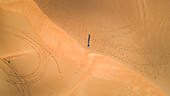 Aerial view of a man walking alone in the dunes of Sharjah desert,U.A.E