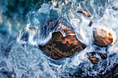 Aerial view of a boulder in the ocean with large waves crashing around it,using a long exposure to capture the motion of the waves,Cape Town,Western Cape,South Africa