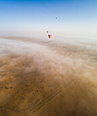 Aerial view of a group of hot-air-balloon flying in the clouds of the Murqquab desert in Dubai,U.A.E