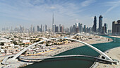 Aerial view of pedestrian arch canal bridge in Dubai with Skyscrapers in background,United Arab Emirates