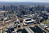 Luftaufnahme des Marvel-Stadions und der städtischen Skyline mit Wasserfront bei sonnigem Wetter, Docklands, Melbourne, Australien