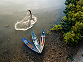 Aerial view of traditional fishing activity with fishermen and wooden boats in shallow water,Ninh Hai,Vietnam